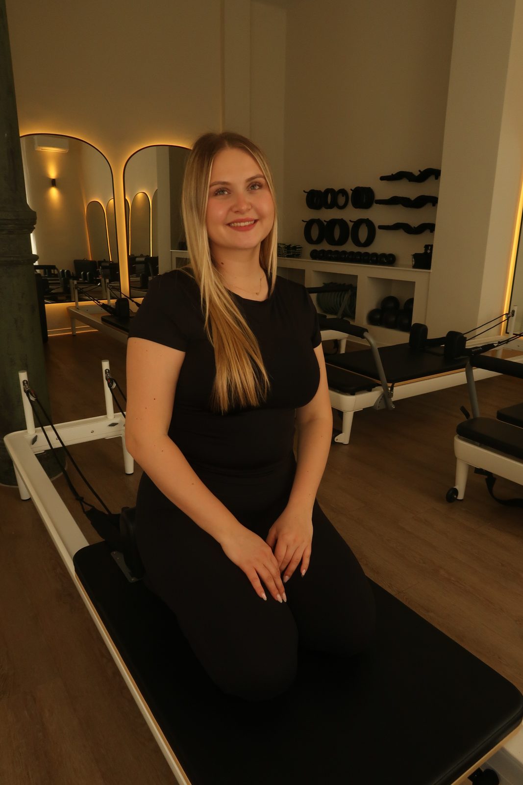 Caroline sitzt im Matcha Moves Studio auf dem Reformer.
