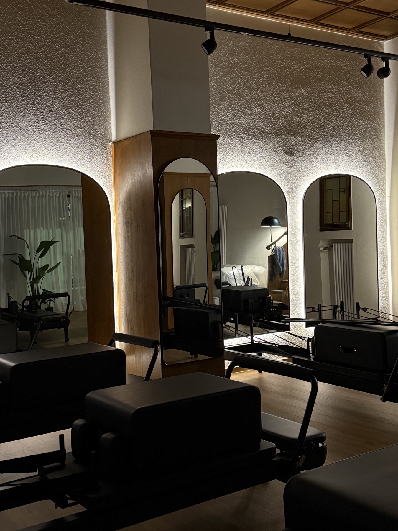 Warm beleuchtetes Matcha Moves Studio mit Spiegeln und Pilates Reformern.